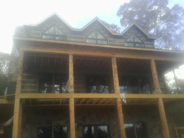 Dormers and porch framing on a large log home under construction — Roof Coating work by our crew in Corydon
