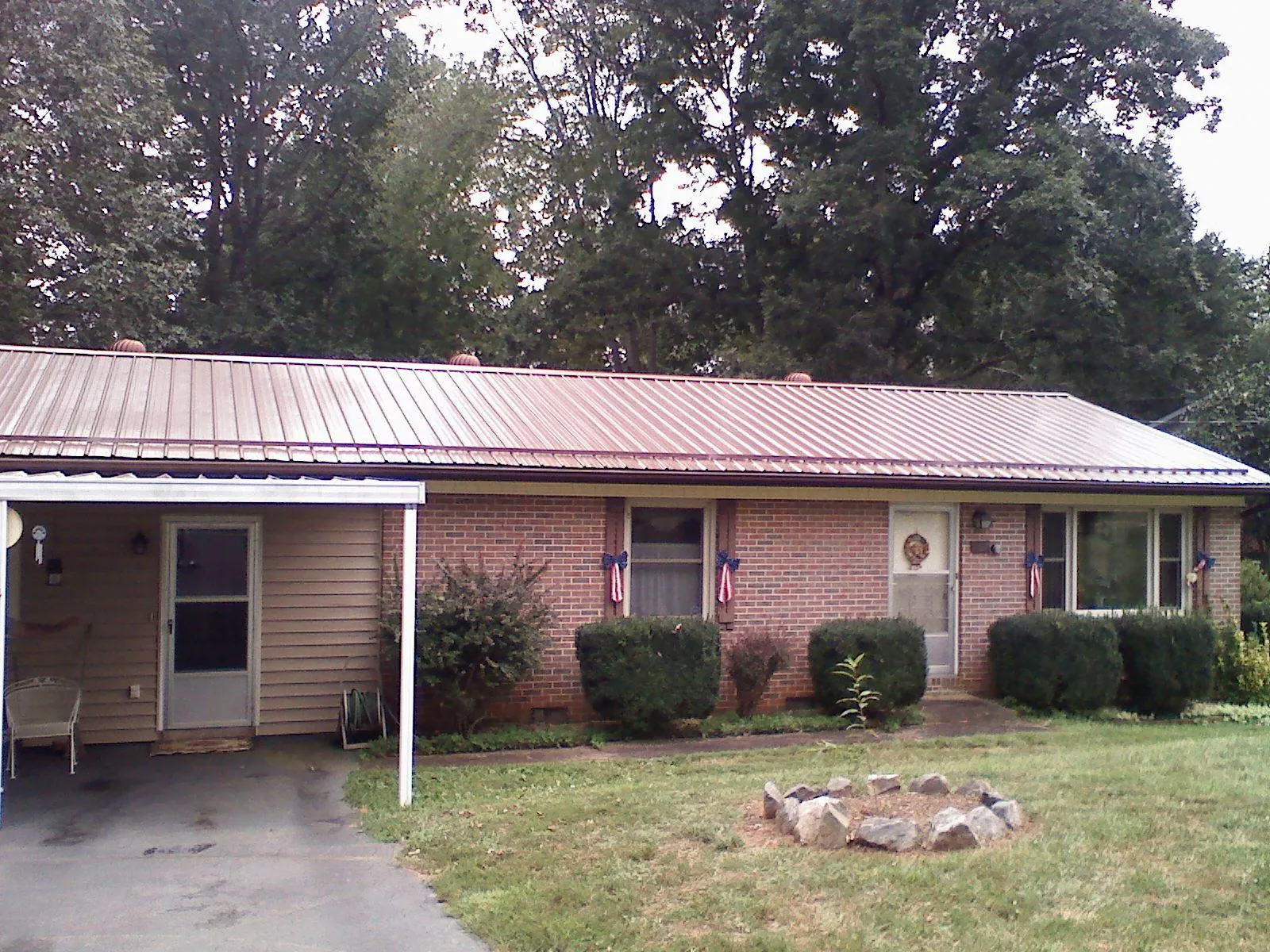 Bronze metal roof and carport on a brick ranch home — Roof Repair work by our crew in Corydon